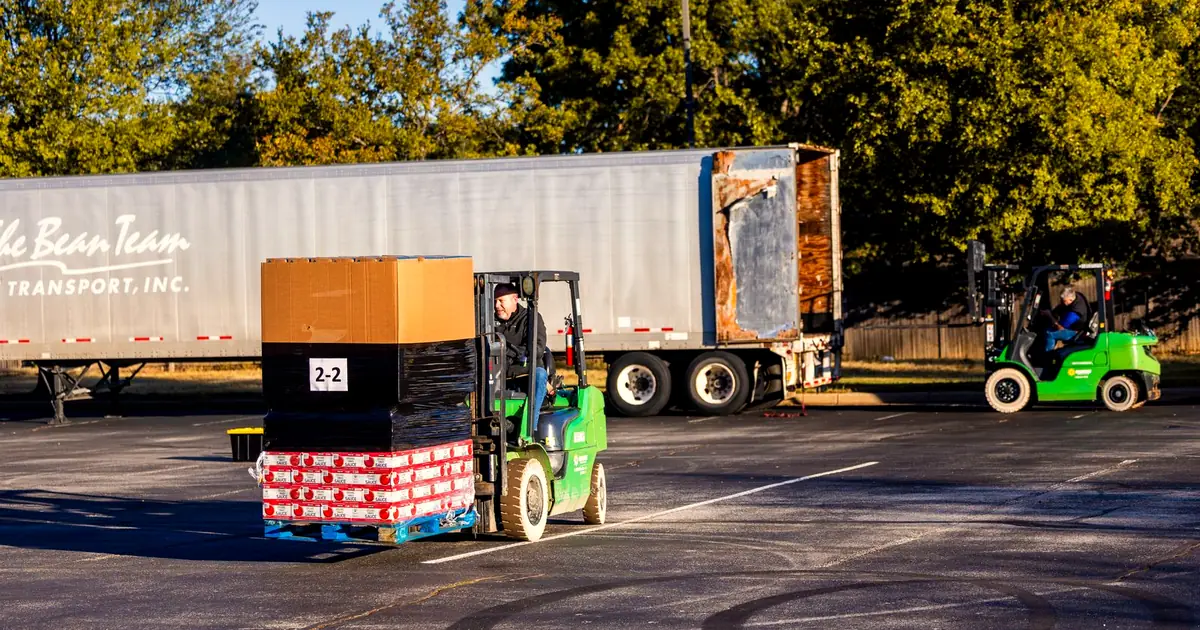 Forklift operator in a hi-vis vest loading pallets