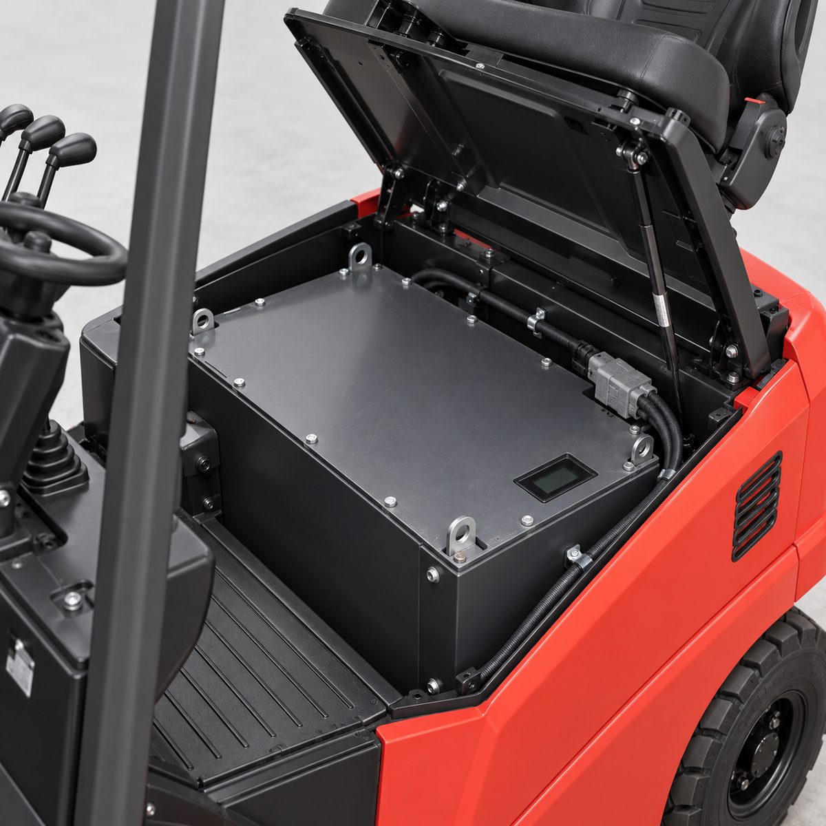 Lithium battery pack in the open compartment of a red electric forklift, seat empty