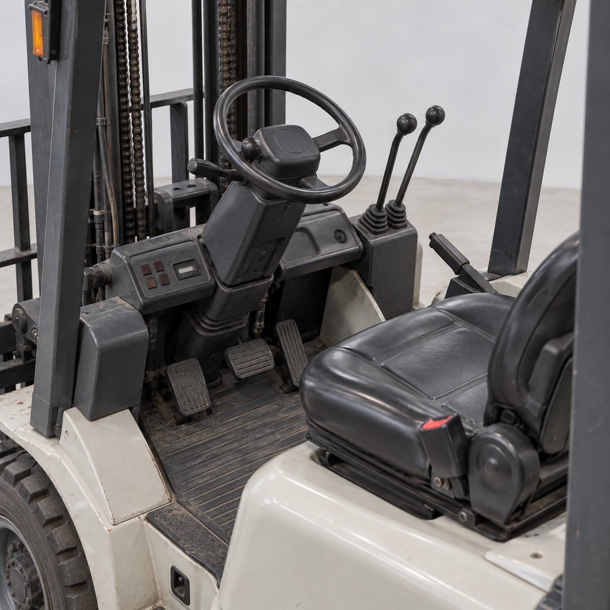 Seat, steering wheel, control levers and dash of a used Komatsu forklift, seat empty