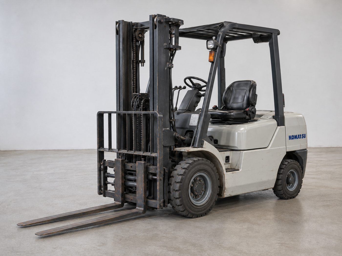 Used Komatsu diesel forklift with off-white body and black overhead guard, front left view